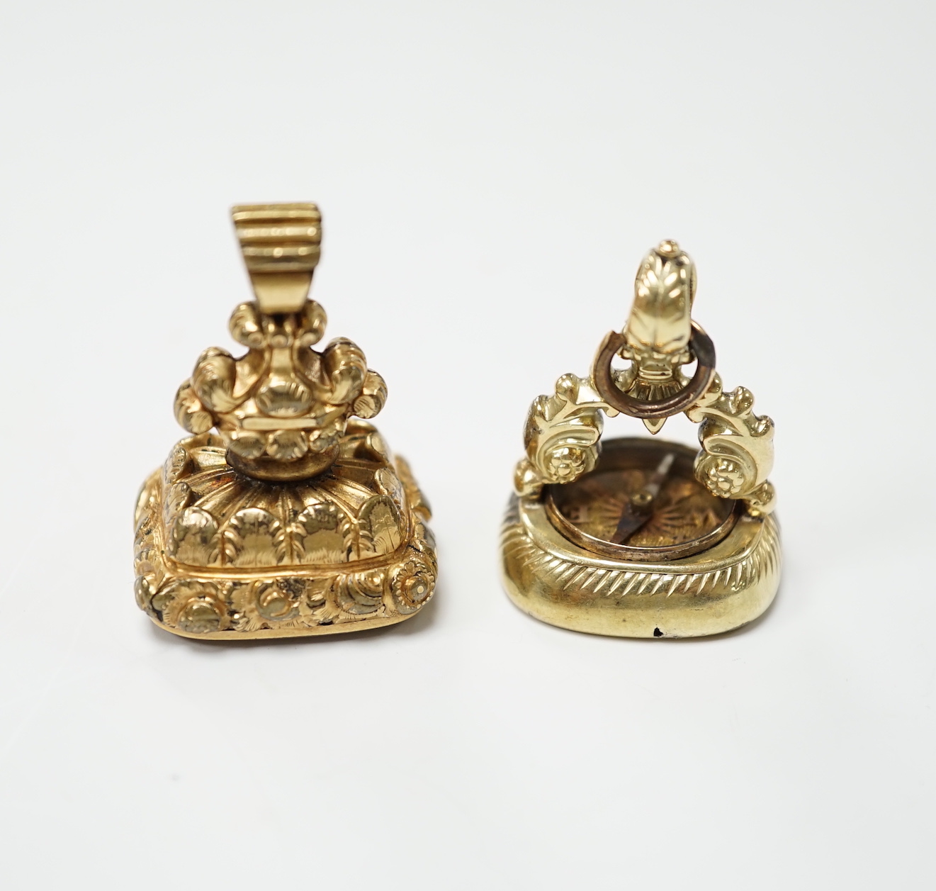 Two 19th century yellow metal overlaid fob seals, the largest 32mm with inset citrine carved with ornate crest and inscribed 'Joy of Life', the other with inset carnelian craved with bee and inscribed 'Non Sibi'.